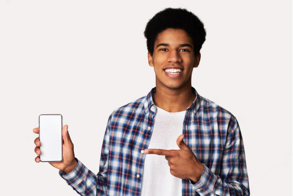 Imagen de un joven sonriente señalando su teléfono celular. Imagen de un joven sonriente señalando su teléfono celular.